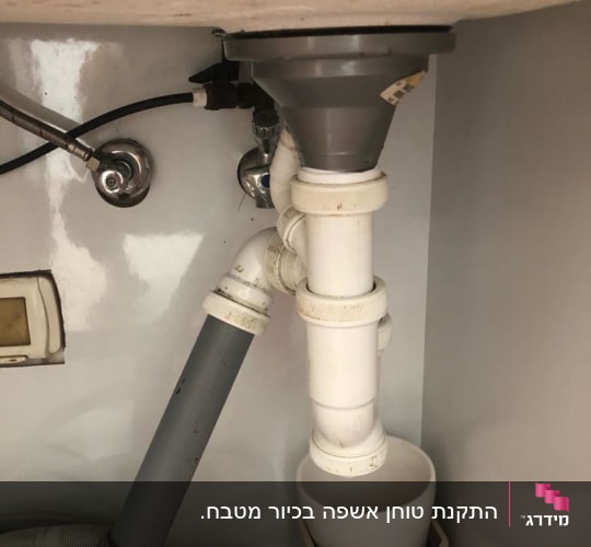 צנרת פלסטיק מתחת לכיור עם מחברים